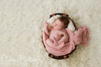 newborn baby girl asleep in basket
