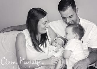 Black and white image of family with baby