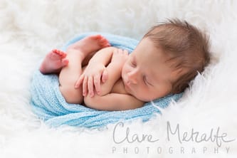 Newborn wrapped in blue fabric
