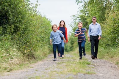 Photograph of family of found running down country lane. 