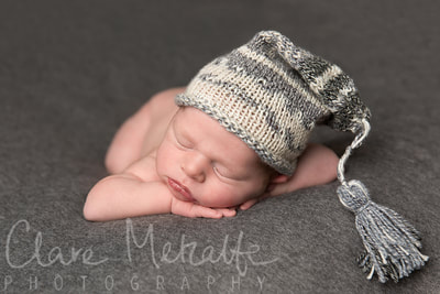 Newborn baby asleep in grey knitted hat