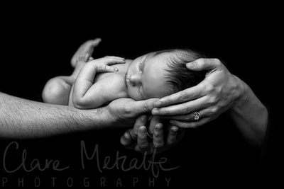 Newborn baby held in parents hands