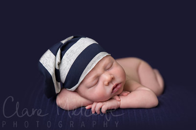 Newborn baby asleep in stripey hat